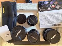 Photo of camera lenses with caps and Tiffen pouch visible