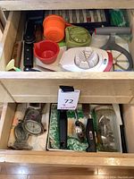 Top drawer with kitchen utensils including knives, egg slicer, measuring cups, and kitchen timers.