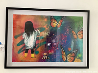Full view of framed art print showing girl with yellow rain boots against colorful background and three monarch butterflies