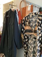 Hangers with black shirt, sleeveless tops, coral tee, olive skirt and orange striped beach tote