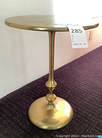 Side view of brass pedestal table showing column and base