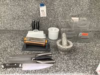 Overview of all items on countertop: knives, sharpener, butterware, mortar and pestle, storage bins