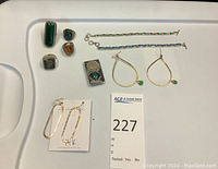 Overview of all jewelry items arranged on tray with lot number card
