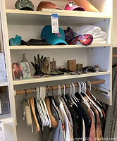 Overall view of shelf showing hats, folded clothing, jewelry display and rack of hanging garments