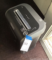 Full view of the Fellowes paper shredder angled showing the top with paper slot and labels.