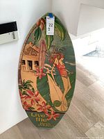 Front view of painted skim board with tropical surf camp artwork and text