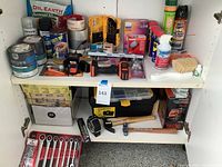 Shelf with assortment of paint supplies, spray cans, lubricants, power tools and toolbox below