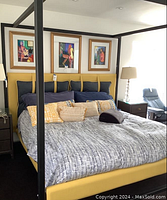 Front view of canopy bed with bedding and cushions