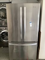 Exterior view of stainless steel Whirlpool side-by-side refrigerator with French doors and bottom freezer drawer