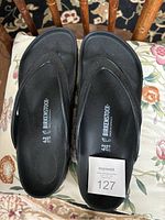 Top down view of black Birkenstock sandals showing the footbed and printed size 42 marking.