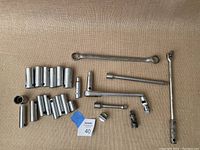 Overview of all socket wrenches, extensions, and adapters spread on fabric surface