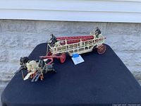 Side view photo of the three horse fire fighter wagon showing entire wagon, horses, and firefighter figures.