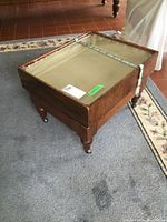 Full view of the display table top showing the glass and wooden frame with ribbon for lifting the glass.