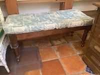 Bench with blue patterned removable cushion on wooden frame and casters