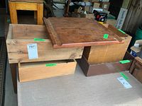 Photo showing four wooden crates stacked and arranged side by side with an 18x18 teak cutting board placed on top of crates.