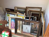 Several wood frames stacked and leaning against the wall, varying sizes and some with visible wear