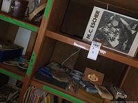 Photo of wooden cubby shelves containing various games, puzzle box, cards, wooden cribbage board, and miscellanea.