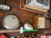 Photo showing the Waymaster analog weigh scale with rust on the platform, ceiling light fixture with cage protective cover, and two vintage wooden speakers (Realistic and Criterion).