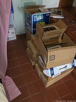 Multiple cardboard boxes stacked containing vintage magazines and other items.