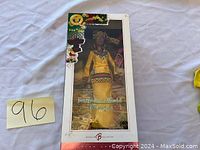 Doll in original packaging with box showing Festival Collection branding and artwork.