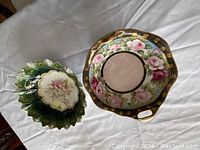 Photo showing two elegant unique decorative bowls, one with a floral rose pattern and gold accents, the other with a green leafy design and floral center.