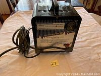 Black large battery charger with attached heavy-duty power cord, front view showing instructions and ammeter.