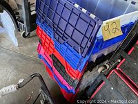Stack of various colored plastic storage containers with lids - blue, red, black, purple, showing approximate size.
