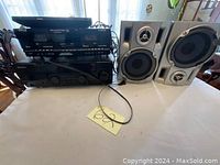 Photo showing a Pyle DVD player, two Sony speakers, and a black stereo receiver/amplifier unit on a table.