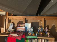 Photo of Christmas snow globes, CDs, and nativity scene on a shelf with wood background.