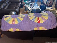 Quilt draped on couch showing overall floral design and colors