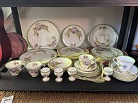 Setup photo showing all the Royal Doulton Glamis Thistle china items on a shelf, including plates, cups, bowls, egg coddlers, and saucers.