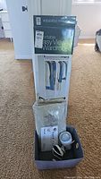 Photo shows the portable easy view wardrobe box standing upright with other items stacked on a fabric basket.