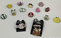 Overview of 15 assorted Disney enamel pins including various character styles and souvenir pins.