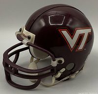 Side angle showing maroon helmet with VT logo, white strap, and faceguard