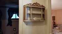 Overall photo showing the wall mounted display shelf holding three decorative dishes.
