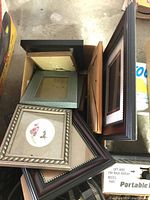 Photo showing various picture frames stacked together, highlighting different styles, colors, and sizes.