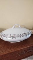 White porcelain Bridgwood and Sons covered serving dish with floral border and ornate handle