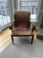 Front view of wooden cane chair showing seat, back, arms, legs