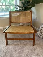 Front view of rattan chair showing wood frame and woven rattan backrest and seat