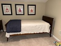 Front view of assembled bed frame with mattress and linens