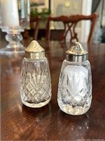 Front angled view of pair showing crystal cut patterns and silver plated tops with discoloration