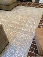 Overall front view of the Ralph Lauren woven area rug laid on a floor with neutral beige and off-white geometric patterns.