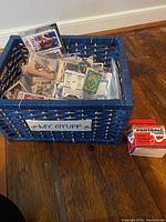 Blue woven basket labeled 'My Stuff' containing loose and sleeved sports cards and unopened Topps 1989 'Traded' Series box