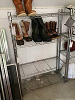 Full view of metal wire rack with boots placed on top two shelves to show scale and condition.