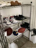 Front view of wire rack with multiple shelves and various sports shoes and balls on it, showing rack structure and size.