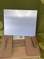 Aluminum metal photo panel 8x10 with clear gloss finish shown leaning on a box.