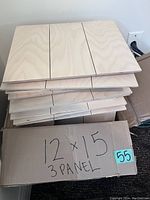 Stack of natural pine wood plaques with 3-panel design and smooth front surface visible, stacked on each other.