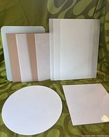 Eight assorted frosted white glass panels in varying rectangular and circular shapes with backing on some panels.