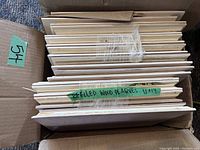 Stack of multiple bevelled pine plaques showing their thickness and bevelled edges.