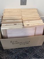 Box containing multiple (31) 8x10 inch natural pine bevelled plaques stacked vertically.